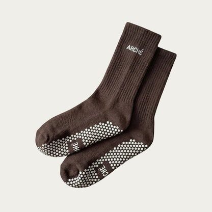 Dark brown ARCHÉ ribbed crew Pilates grip socks with white non-slip sole grips for yoga, barre and studio workouts.