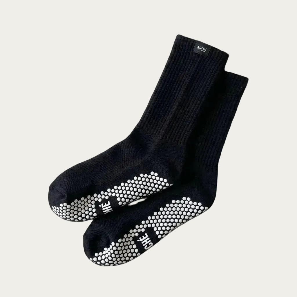 Black ARCHÉ crew Pilates grip socks with white non-slip sole grips for yoga, barre and studio workouts.