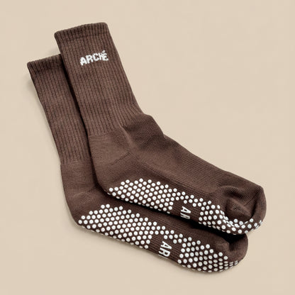 Brown ARCHÉ crew Pilates grip socks with white non-slip sole grips for yoga, barre and studio workouts.
