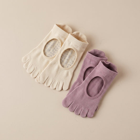 Cream and dusty mauve five-toe Pilates non-slip grip socks by ARCHE with a minimalist open-top design, shown flat on a neutral background.