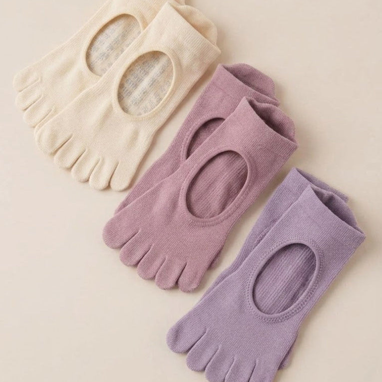 Cream, dusty mauve and lavender ARCHE five-toe non-slip grip socks for Pilates, yoga, barre and studio workouts.