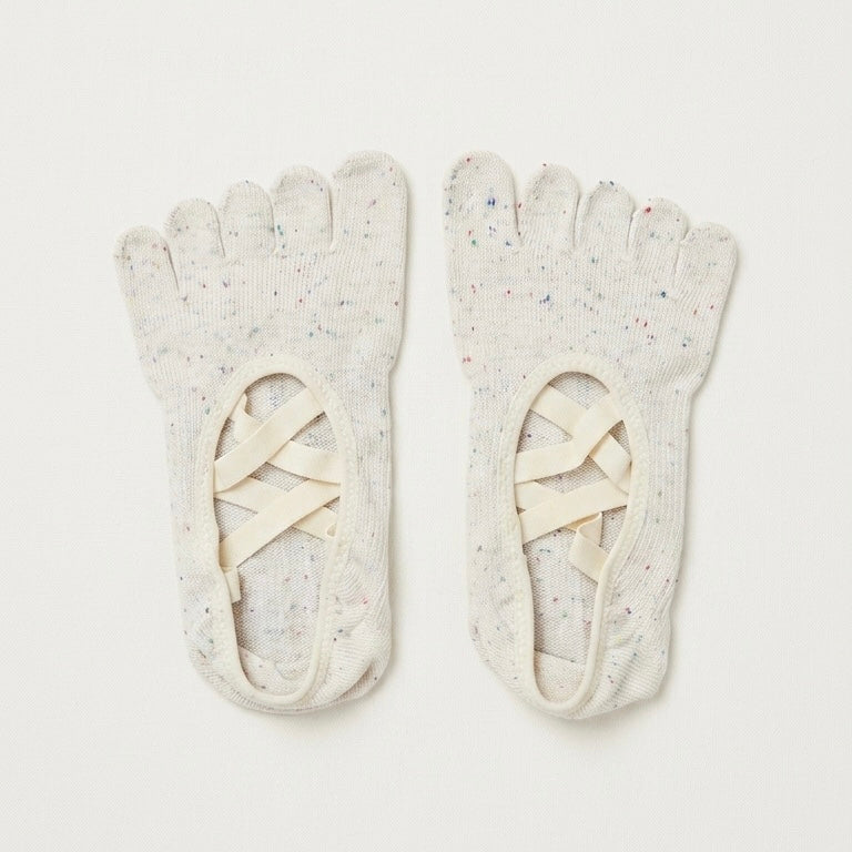 Ivory Cream speckled five-toe Pilates grip socks by ARCHE with ballet-inspired crisscross straps for reformer Pilates and studio workouts.