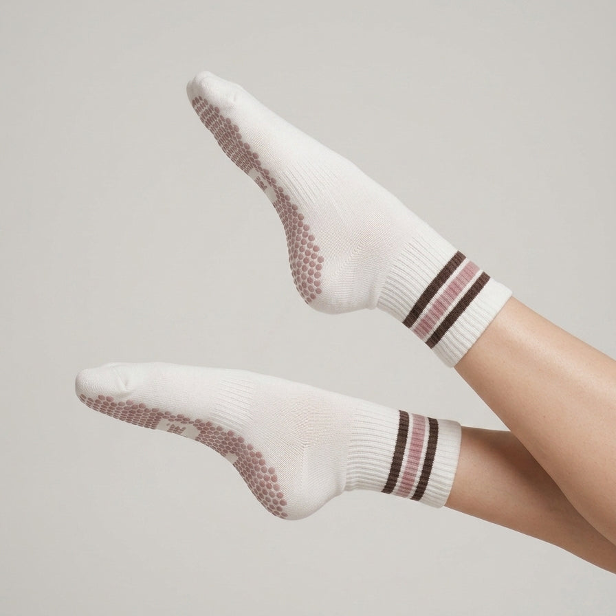 Model wearing ivory ARCHÉ striped crew Pilates grip socks with non-slip grips for yoga, barre and studio workouts.