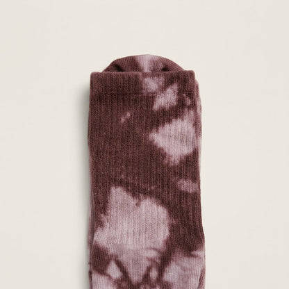 Close-up of dusty mauve boho tie-dye Pilates grip socks with ribbed crew construction and soft mauve plum studio style.